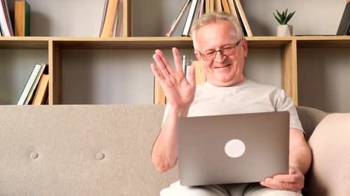 Senior Man Video Calling on Laptop at Home