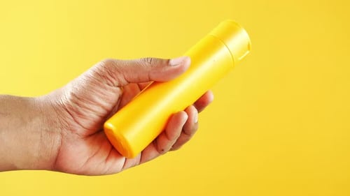 Personne tenant une crème solaire dans la main