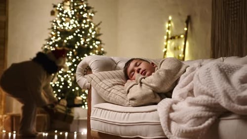 Child Sleeps as Parent Places Christmas Gifts