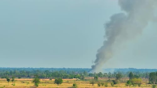 Smoke Rises Above Rural Countryside Landscape