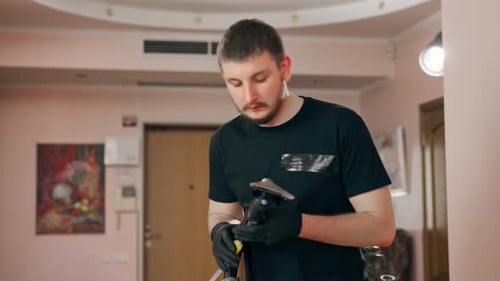 Man Cleaning Couch with Upholstery Cleaning Machine