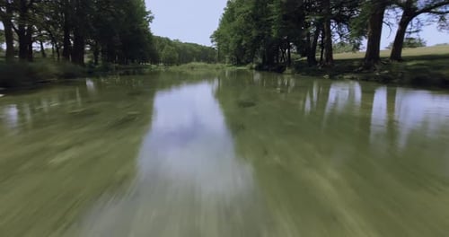 An aerial shot of a river in the early afternoon reflects the tranquility of the clouds on its surfa
