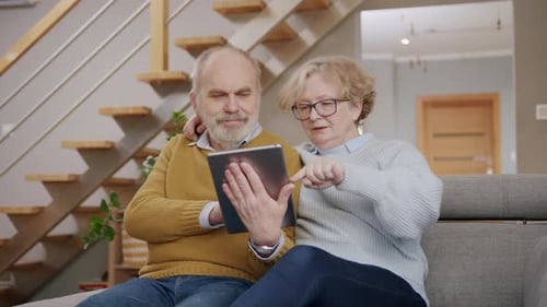 Senior Couple Using Digital Tablet on Sofa