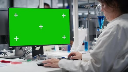 Lab Technician at Desk Typing on Green Screen PC Keyboard
