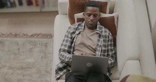 Young Adult Working on Laptop at Home