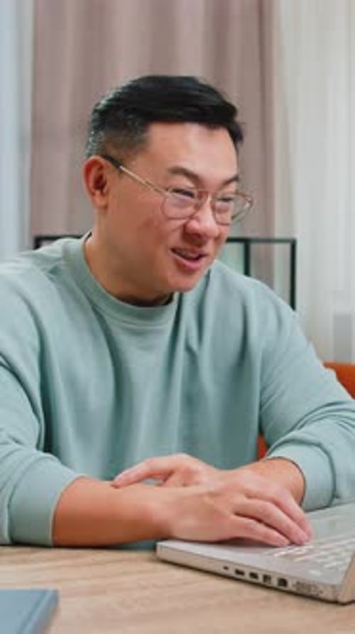 Man Video Conferencing on Laptop in Home Setting