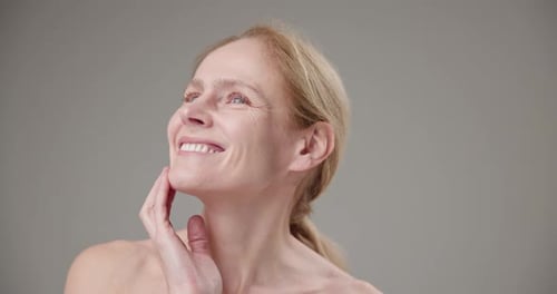 Smiling Blonde Woman Touching Her Face
