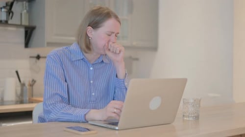 Woman Coughing While Working On Laptop At Home