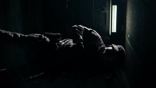 Soldier with Rifle Laying in the Dark