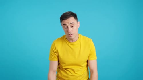 Man Sneezing and Wiping Nose Against Turquoise Background