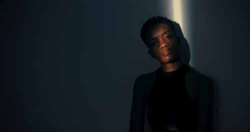 Woman Posing in Shadowy, Dimly Lit Room