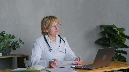 Female Doctor Working at Desk with Laptop
