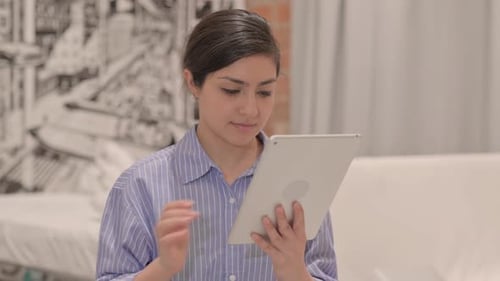 Young Adult Woman Using Tablet Device Indoors