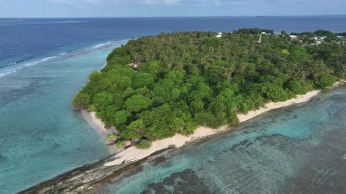Aerial view of lush island with blue waters, Maldives.