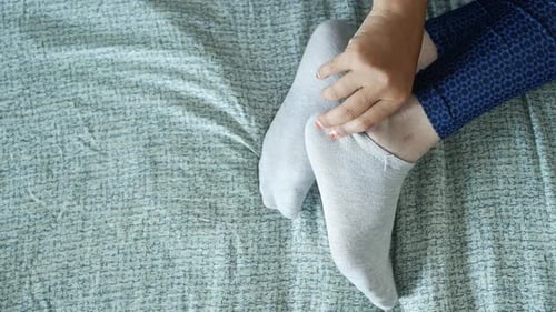 Person putting on ankle socks at home