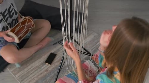 Women Weaving Macrame and Playing Drum Together at Home