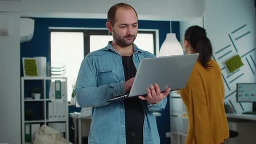Man Working on Laptop in Modern Office