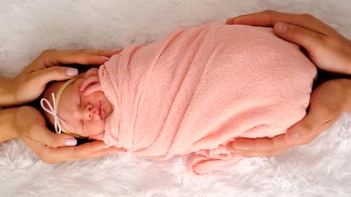 Precious Newborn Swaddled in Parents' Loving Hands