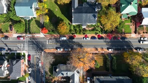 American town in autumn. Aerial top down truck shot of houses and homes lining street with colorful