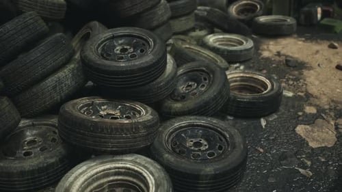 Discarded Tires Stacked in a Junkyard During an Overcast Afternoon