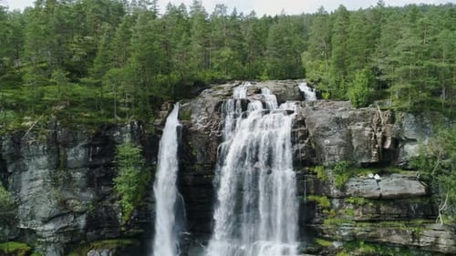 Tvinde Waterfall Cascading Down Rocky Cliffs Amidst Lush Norwegian Forest, Drone