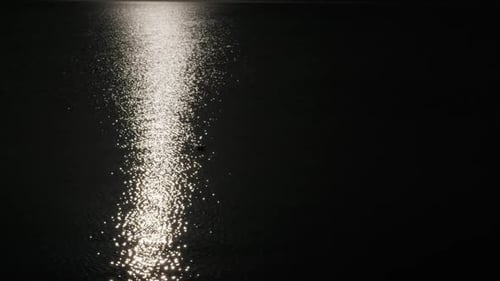 Bright Moonlight Reflection Sparkling on Dark Water Surface