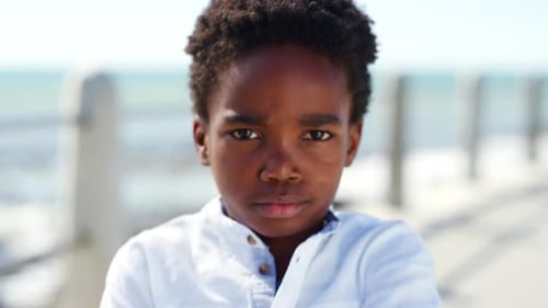 Arms crossed, face and tantrum with black kid on promenade for holiday, travel or vacation