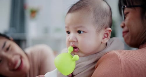 Happy Baby with Family Plays with Toy Indoors