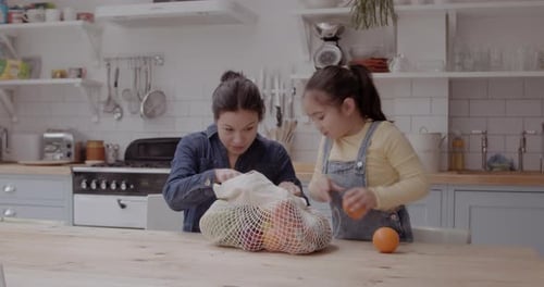 Woman and Child with Fruit in Kitchen