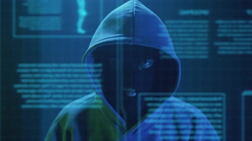 Hooded Hacker in Front of Holographic Display