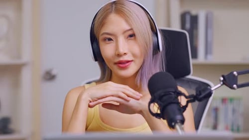 Young Woman Smiles with Microphone and Headphones