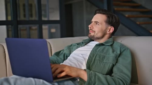 Young Man Working on Laptop Indoors