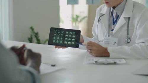 Female Doctor Showing CT Scan And Giving Consultation