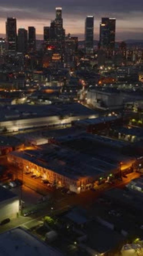 High Angle View of Buildings Along Illuminated Streets Tilt Up Revealing Cityscape with High Rise