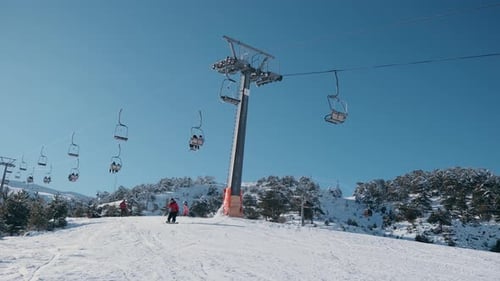 Skifahrer unter einem Sessellift auf einem verschneiten Berg — Wintersport und alpine Landschaft