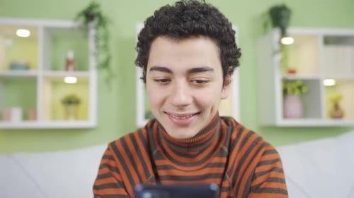 Young Adult Using Mobile Phone at Home