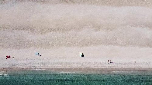Seashore coastline drone aerial view of people at unspoiled beach in Almeria, Playa de los Muertos
