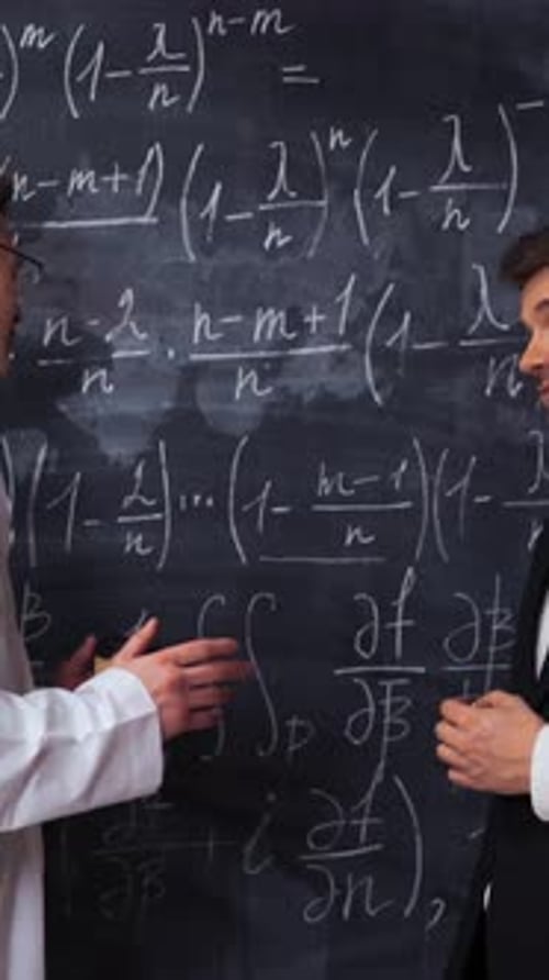 Vertical of Two Scientists Writing Discussing and Analyzing Math Equations on a Chalk Desk Board