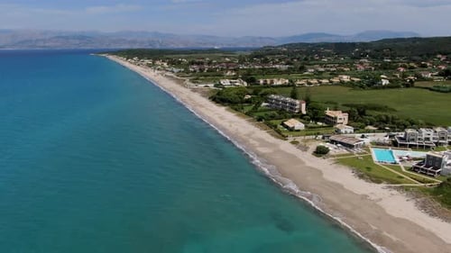 Aerial Drone View of Long Sandy Beach with Luxury Villas, Resorts, and Pools next to Turquoise Sea