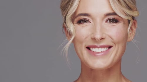 Studio Portrait of Young and Beautiful Blond Woman Over Grey Background Skin Care and Wellness