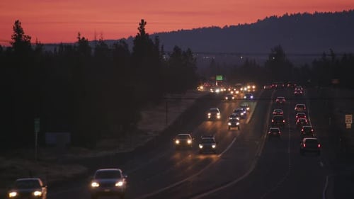 Autobahnverkehr bei Sonnenuntergang, der in der Abenddämmerung durch die Kurve Oregon fließt