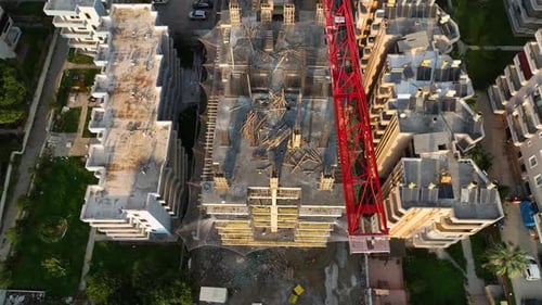 Aerial Flight Over the Construction Site of New Structures with Tall Tower Cranes