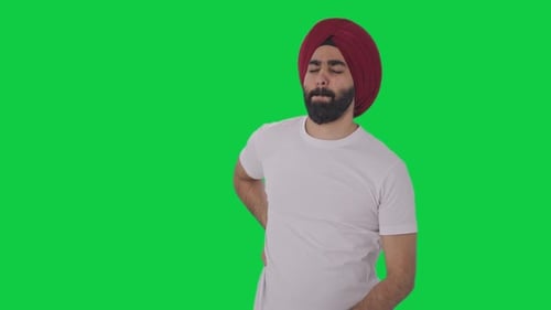 Sick Sikh Indian man suffering from back pain Green screen