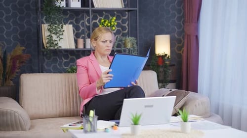 Home office worker woman looking at the file angrily.
