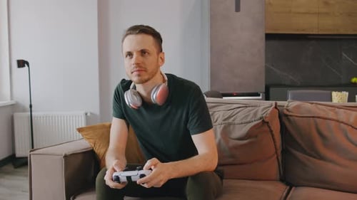 Man Playing Video Game on Couch at Home