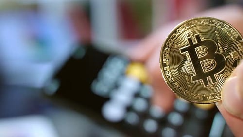 Bitcoin-Kryptowährungsgeschäft. Mann, der eine goldene Bitcoin-Münze hält. Investition in das Bitcoin-Geschäft. P...