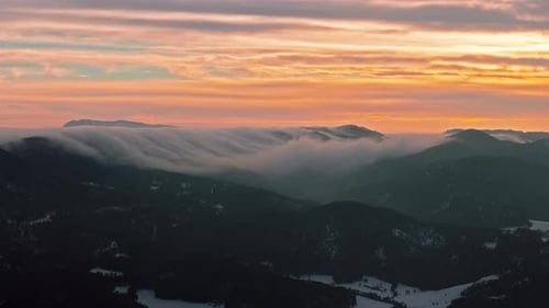 Goldene Wolken über nebligen Berggipfeln 4K