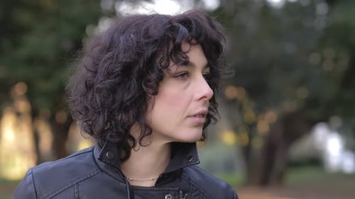 attractive fashion young woman turning and smiling at camera in the park