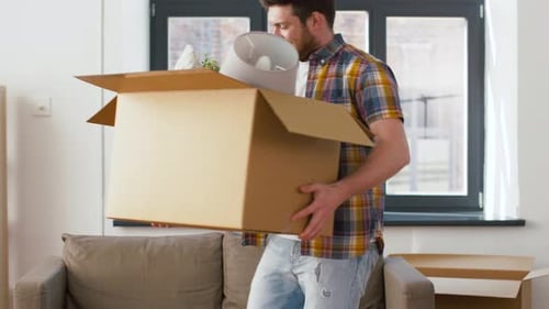 Man Carrying Cardboard Box with Belongings into New Home