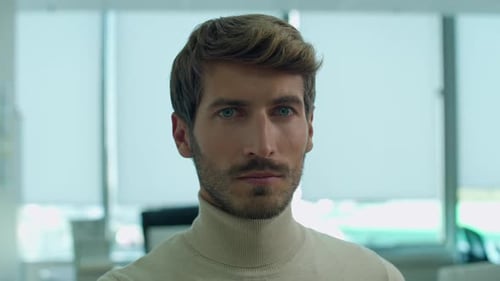 Handheld Portrait of a Young Designer Working in a Office Focused Man Looks at the Camera and Smiles